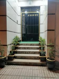a door in a building with stairs and potted plants at Complexe zohour in Tangier