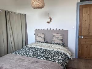 una camera da letto con un letto con cuscini sopra di Appt lumineux - 2 chambres - Mer et commerces a Berck-sur-Mer