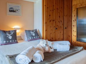 a teddy bear sitting on a bed with towels at Studio Christiania I R3 by Interhome in Nendaz
