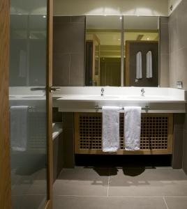 y baño con lavabo, espejo y toallas. en Hotel Playa Calera, en Valle Gran Rey