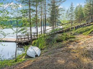 ein Boot, das am Ufer eines Flusses neben einer Brücke liegt in der Unterkunft Holiday Home Papulantupa by Interhome in Kulho