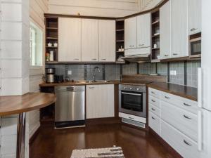 eine Küche mit weißen Schränken und Küchengeräten aus Edelstahl in der Unterkunft Holiday Home Papulantupa by Interhome in Kulho