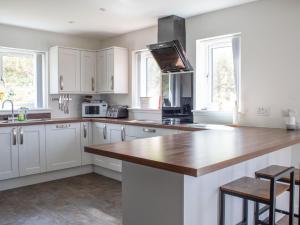 a kitchen with white cabinets and a wooden counter top at Holiday Home One Mill Lands by Interhome in Uig