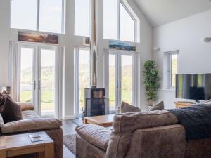a living room with two couches and a tv at Holiday Home One Mill Lands by Interhome in Uig