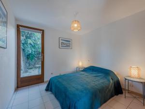 ル・バルカレスにあるHoliday Home Hameau des Tamarins-2 by Interhomeのベッドルーム1室(ベッド1台、テーブル2台、窓付)