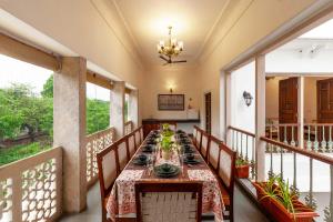 a dining room with a table on a balcony at Kanak Vilas by StayVista, a Rajasthani haveli boutique stay with hill views, offering both indoor and outdoor games for a delightful retreat in Jaipur