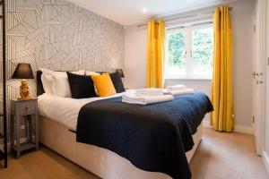 a bedroom with a bed with towels on it at Trewhiddle Villa 03 in St Austell