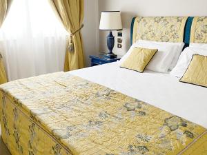 a bedroom with a large bed with a yellow and blue blanket at Altafiumara Resort & Spa in Villa San Giovanni