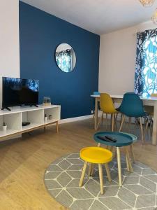 a living room with chairs and a blue wall at Agréable 3 chambres Le Muguet in Besançon