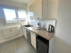 a small kitchen with a counter and a refrigerator at Agréable 3 chambres Le Muguet in Besançon