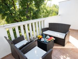 un balcón con 2 sillas y una mesa con fruta. en Holiday Home Labin by Interhome, en Labin