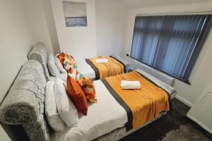 a room with two beds and a couch and a window at Saint Johns 3-bedroom House-Greater London in Dartford