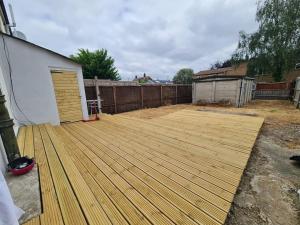 una terraza de madera en un patio trasero con una valla en Saint Johns 3-bedroom House-Greater London, en Dartford