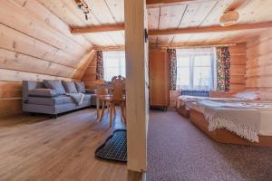 1 dormitorio en una cabaña de madera con 1 cama y 1 mesa en Kiry 9 - pokoje i apartamenty, en Kościelisko