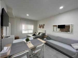 una sala de estar con un sofá y una mesa en Málaga centro estudio precioso 4, en Málaga