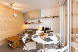 Zimmer mit einem Tisch, Stühlen und einem Sofa in der Unterkunft SweetLoc - Appt au pied des Pistes au Corbier in Villarembert