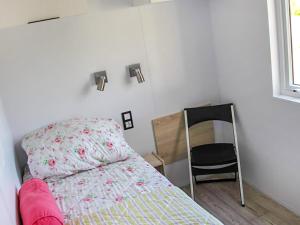 a small bedroom with a bed and a chair at Holiday Home Natuurlijk de Veenhoop by Interhome in De Veenhoop +7 photos