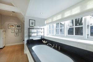 a large bathroom with a large tub and a window at Amsterdam Mansion - Suite De Dam in Oostzaan