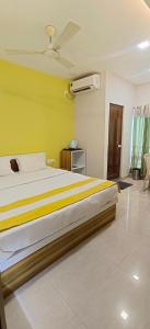 a bedroom with a large bed with a yellow wall at CHIRAGDEEP BANQUET HALL AND LODGING in Jalpāiguri
