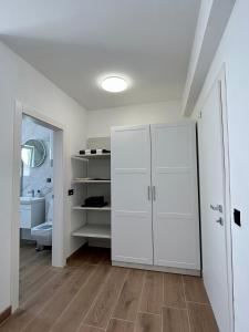 a white bathroom with a toilet and a closet at Harmony suites in Bol +60 photos