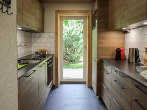 切希爾雷斯的住宿－Apartment Chantebrise A1 by Interhome，厨房配有木制橱柜和通往庭院的门