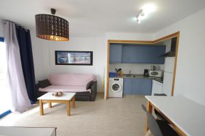un soggiorno con divano e tavolo di Livingtarifa Apartamento Blue I a Tarifa