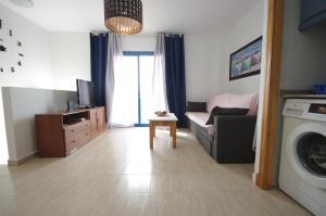 a living room with a couch and a washing machine at Livingtarifa Apartamento Blue I in Tarifa