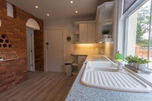a kitchen with a sink and a brick wall at Stunning Rural Apartment - Sleeps 6 - Parking in Lichfield