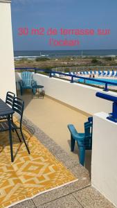 BELLE VUE OCEAN, 2 CHAMBRES, terrasse 30m2, parking privatif et piscine en été في لاكانو-أوسيان: تقديم بلكونه مع الكراسي والطاولات