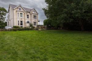 una casa grande con un gran campo de hierba delante de ella en Stunning Rural Apartment - Sleeps 6 - Parking, en Lichfield