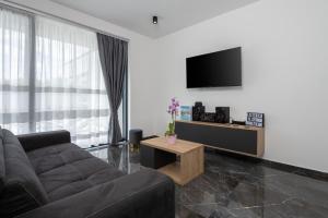 a living room with a couch and a flat screen tv at Villa Alison Deluxe Junior with private spa and heated swimming pool in Nedeščina