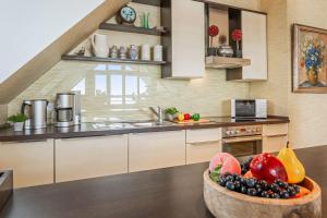a kitchen with a bowl of fruit on a table at Wellness-Apartment mit Wasserblick, Pool, Sauna & Fitnessbereich in Rankwitz