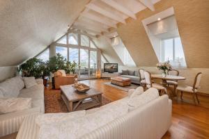 a living room with white furniture and a large window at Wellness-Apartment mit Wasserblick, Pool, Sauna & Fitnessbereich in Rankwitz