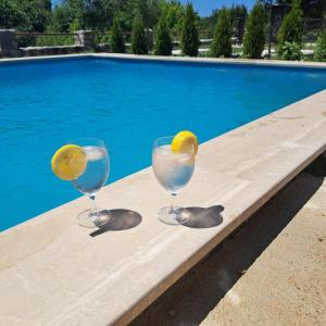 twee glazen water en een citroen op een tafel bij een zwembad bij Stanovcic Apartments in Herceg-Novi