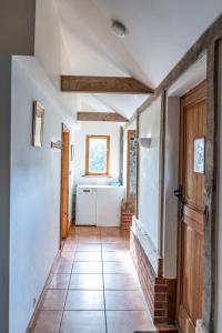 - un couloir dans une maison revêtue de carrelage dans l'établissement Cart Lodge - Holly Tree Barns, à Halesworth