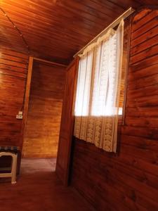 a window in a room with a wooden wall at MOUNTAIN HOUSE in Roshka