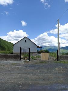 a white barn with a fence in front of it at MOUNTAIN HOUSE in Roshka