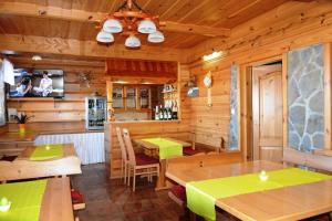 a dining room with wooden walls and wooden tables at Penzion pod Tatrami in Ždiar