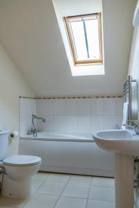 a bathroom with a toilet and a tub and a sink at Cart Lodge - Holly Tree Barns in Halesworth