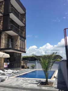 een uitzicht op een gebouw met een zwembad en een palmboom bij Nona's House and Aparts in Kobuleti