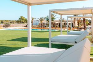 - deux lits blancs sur une pelouse à côté d'une piscine dans l'établissement Cantó de Marina- Adults Only, à Campos