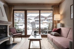 a living room with a couch and a fireplace at Post Alpina - Family Mountain Chalets in San Candido