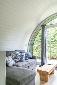 a living room with a couch and a table at Glamping Pod Two - Holly Tree Barns in Halesworth