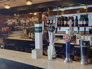 a bar with a counter with bottles of alcohol at Cliffe Norton in Tenby