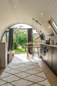 eine Küche mit einem Tisch und einem großen Fenster in der Unterkunft Glamping Pod Two - Holly Tree Barns in Halesworth