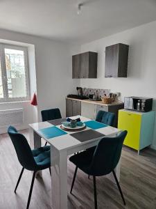 una cucina con tavolo e sedie in una stanza di Appartement 4 personnes vue mer à Santec au pied de la plage du Dossen a Santec