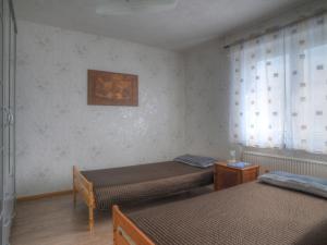 Cette chambre comprend 2 lits et une fenêtre. dans l'établissement Apartment Ella by Interhome, à Bromskirchen