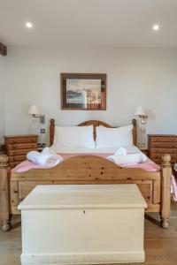a bedroom with a large wooden bed with two pillows at The Dairy - Holly Tree Barns in Halesworth
