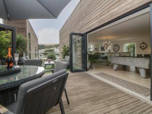 a living room with a glass table and a pool table at 12 Beachdown in Kingsbridge