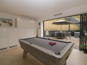 a living room with a pool table and a dining room at 12 Beachdown in Kingsbridge